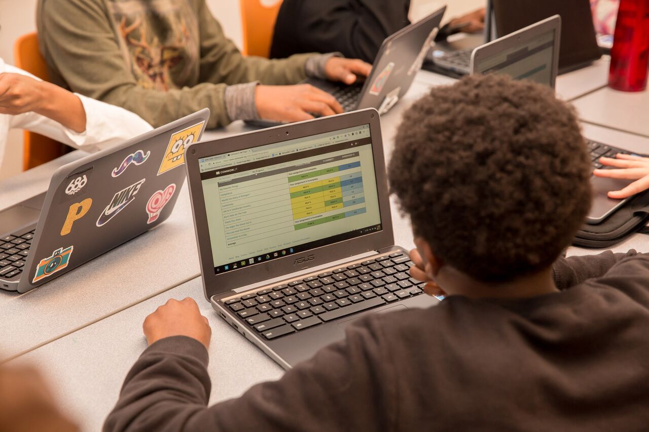 Estudiante frente a una computadora, mirando su desempeño en la página de Reporte de Actividades de la plataforma CommonLit.