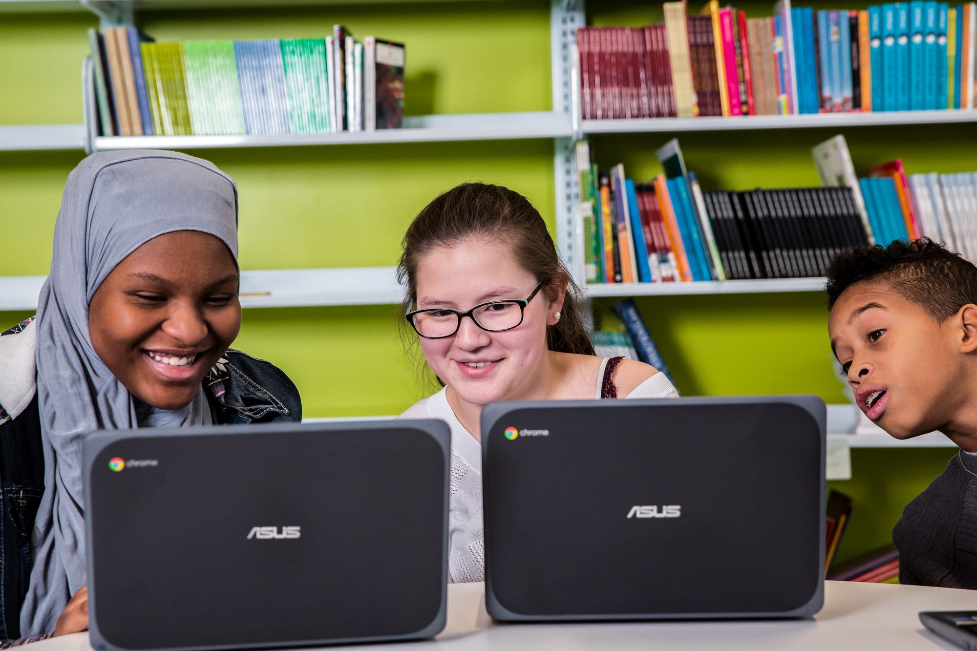 Students are smiling while they are looking at their computers and doing a lesson.