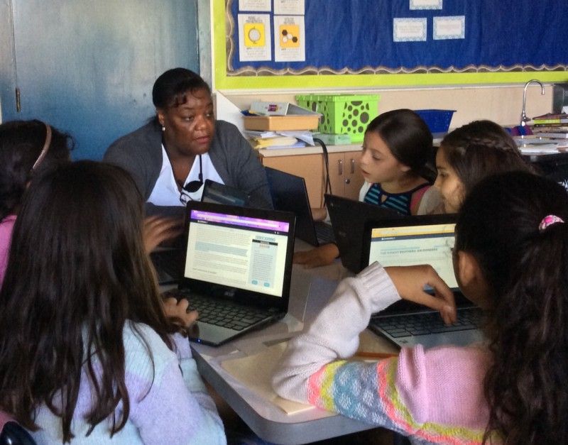 A teacher and students reading during a lesson. 