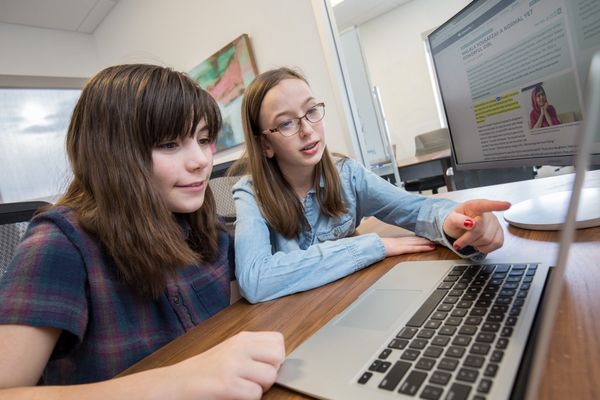 Two students look at a computer screen. 