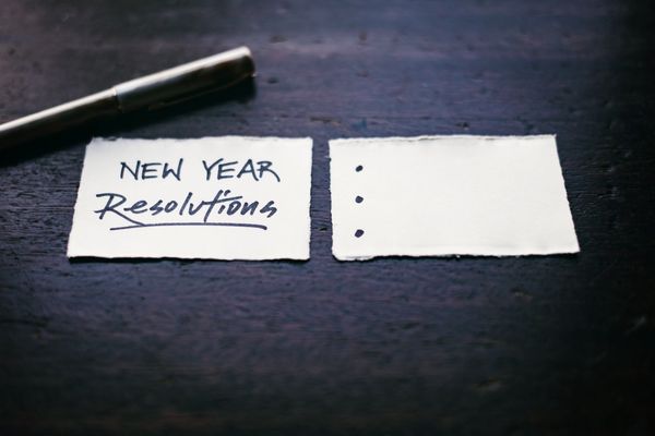 Dos papeles, uno que dice "New Year Resolutions" y uno blanco. 